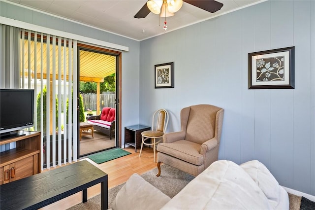 living room featuring ornamental molding, wood finished floors, and ceiling fan
