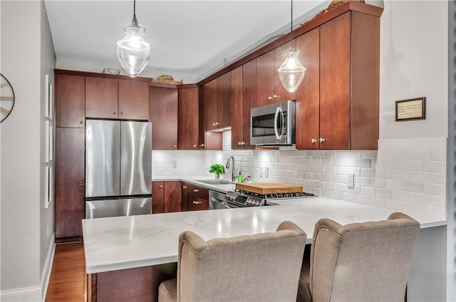 132 Lakefront Blvd Unit 104, Buffalo, NY 14202 - kitchen with stainless steel appliances, a sink, a peninsula, and tasteful backsplash