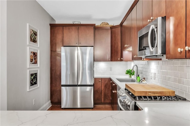 132 Lakefront Blvd Unit 104, Buffalo, NY 14202 - kitchen with stainless steel appliances, a sink, tasteful backsplash, and light stone countertops