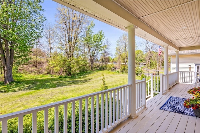 deck featuring a porch and a yard
