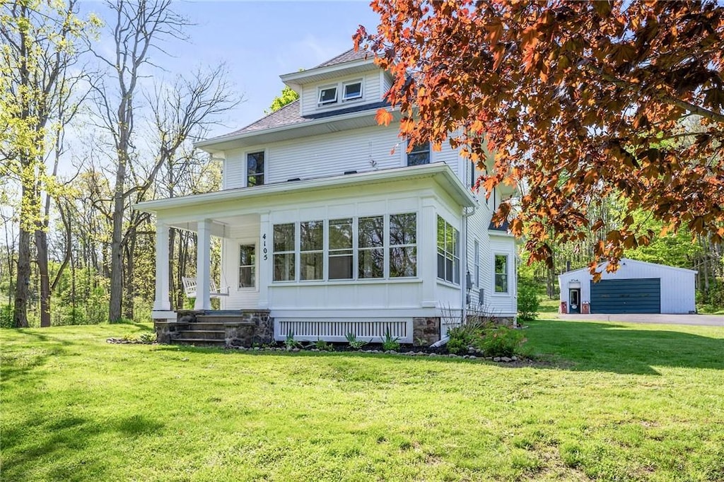 4105 N Creek Rd, Palmyra, NY 14522 - back of house featuring a yard, covered porch, and a detached garage
