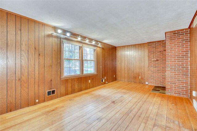 empty room featuring hardwood / wood-style flooring and wooden walls