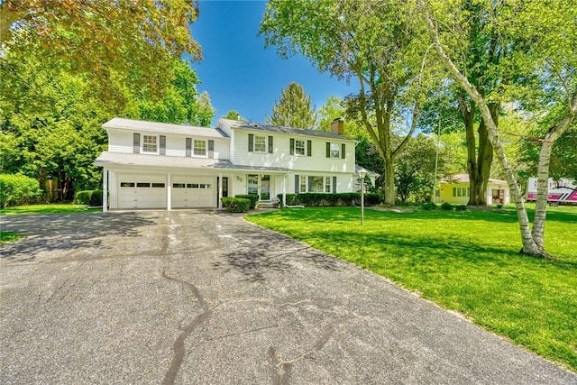view of front facade with a chimney, driveway, and a front yard