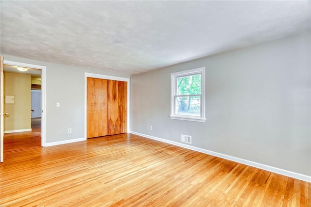 spare room featuring baseboards and light wood-type flooring