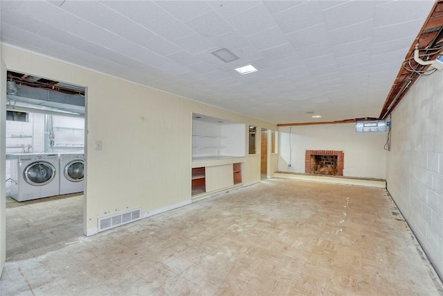 unfurnished living room with a brick fireplace and washing machine and clothes dryer