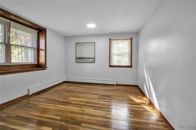 spare room with wood-type flooring, baseboards, a baseboard heating unit, and recessed lighting