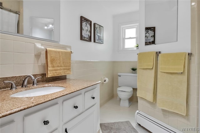 full bath featuring a baseboard radiator, tile walls, toilet, vanity, and wainscoting