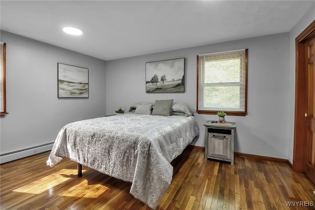 bedroom featuring hardwood / wood-style flooring, baseboards, a baseboard radiator, and recessed lighting