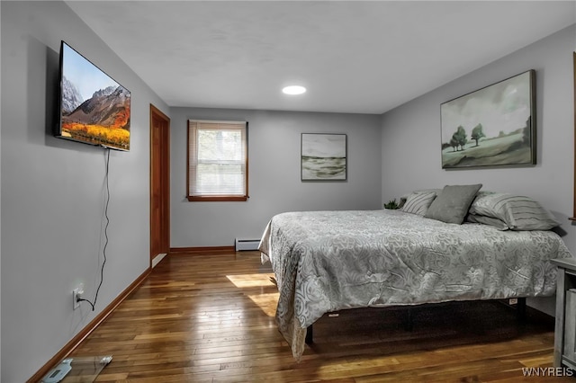 bedroom featuring baseboard heating, wood-type flooring, baseboards, and recessed lighting