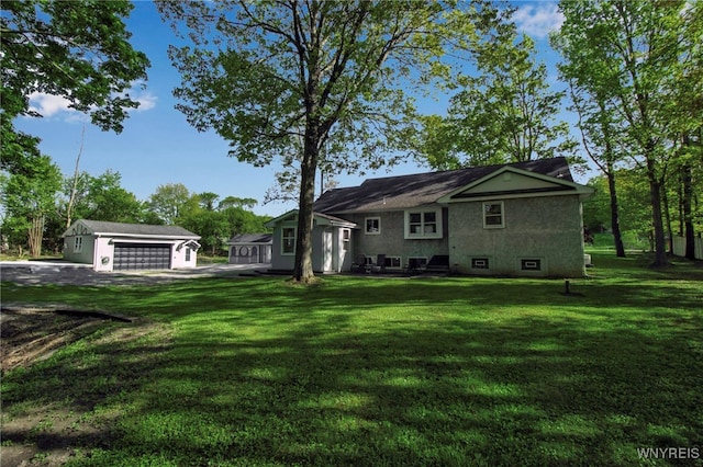 back of property featuring an outbuilding, a yard, and a detached garage