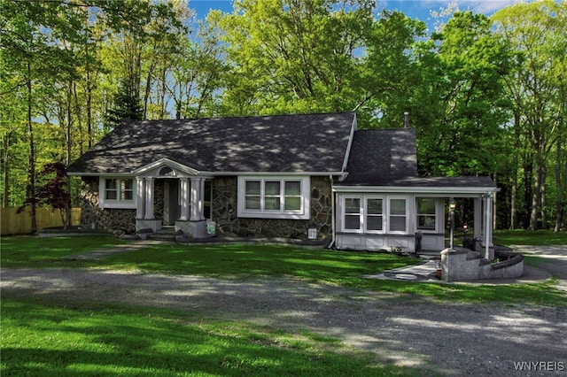 view of front facade with stone siding and roof with shingles