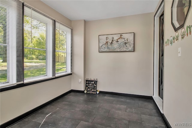 unfurnished room with baseboards