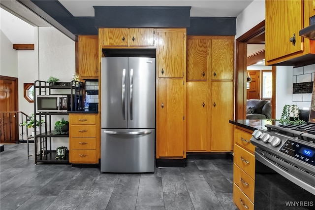 kitchen with stainless steel appliances, dark countertops, and brown cabinets