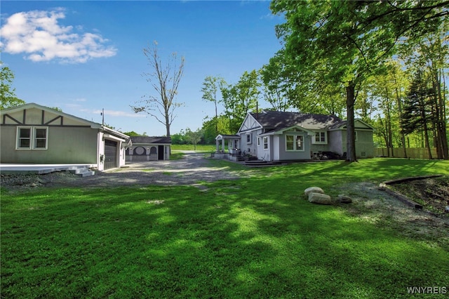 view of grassy yard with an attached garage and driveway