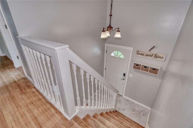foyer with a chandelier, baseboards, and light wood-style flooring