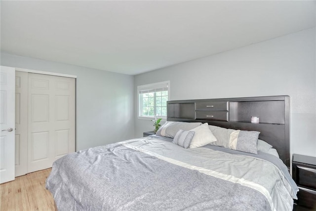 bedroom with light wood-type flooring and a closet