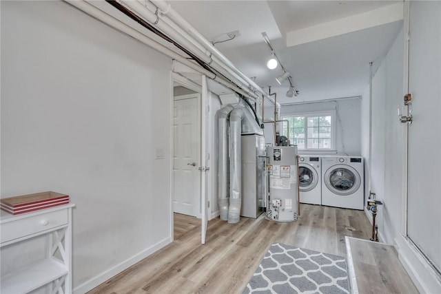 laundry area with water heater, washer and dryer, and wood finished floors