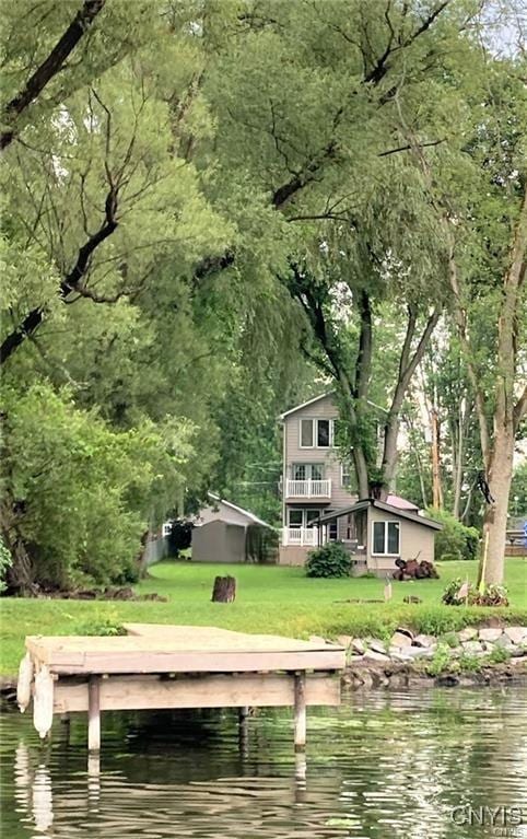 dock featuring a water view and a lawn