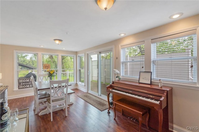 sunroom / solarium featuring baseboards, healthy amount of natural light, wood finished floors, and recessed lighting
