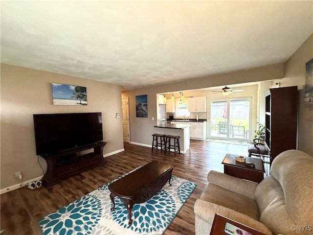 1004 W Thomas St, Rome-Inside, NY 13440 - living room featuring baseboards, dark wood-type flooring, and a ceiling fan