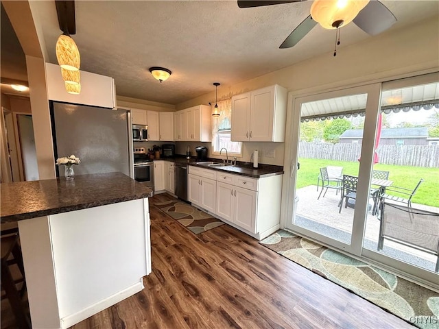 1004 W Thomas St, Rome-Inside, NY 13440 - kitchen with appliances with stainless steel finishes, dark countertops, a sink, white cabinetry, and a textured ceiling