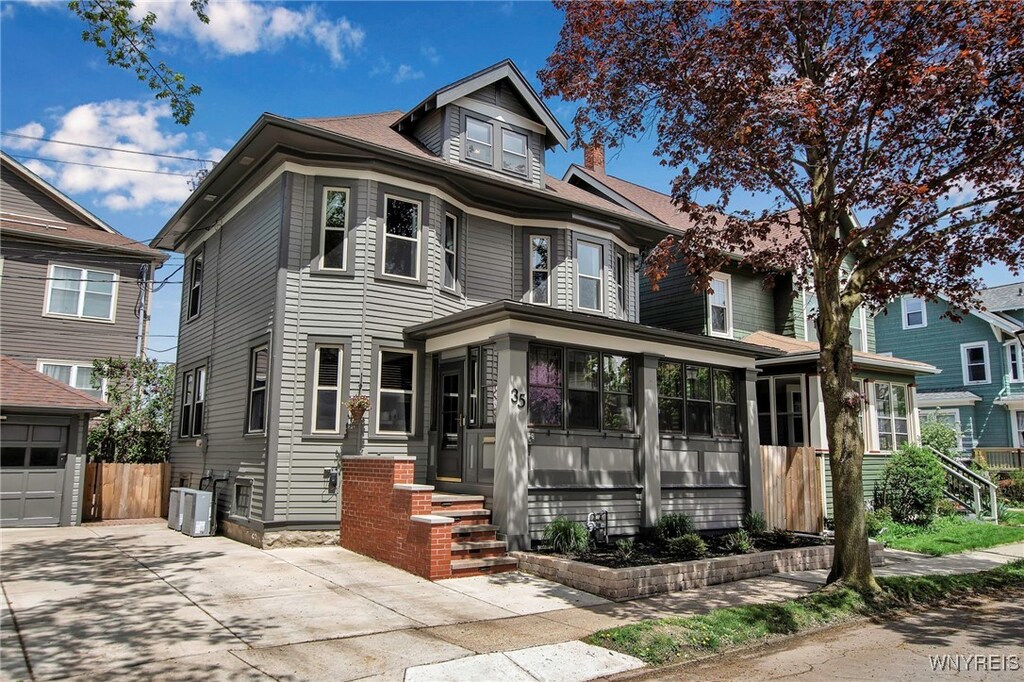 35 Revere Pl, Buffalo, NY 14214 - traditional style home featuring a sunroom, central air condition unit, concrete driveway, and fence