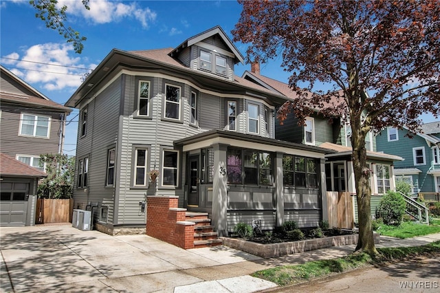 35 Revere Pl, Buffalo, NY 14214 - traditional style home featuring a sunroom, central air condition unit, concrete driveway, and fence