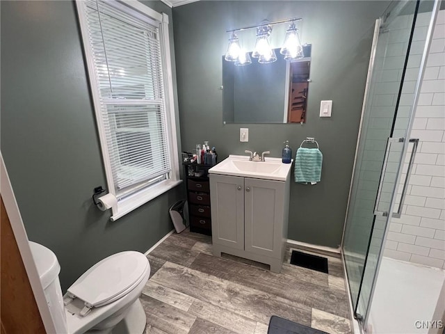 full bathroom featuring toilet, a stall shower, vanity, and baseboards