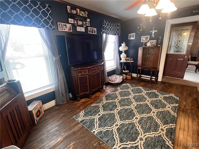 living room featuring wood-type flooring, baseboards, and ceiling fan