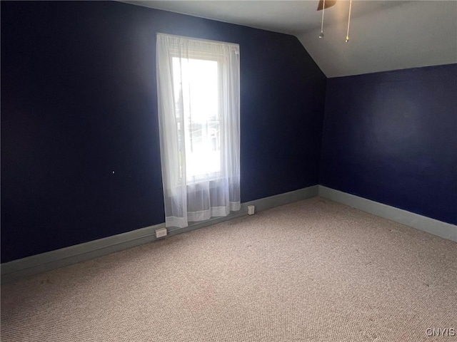 additional living space featuring vaulted ceiling, carpet flooring, baseboards, and a ceiling fan
