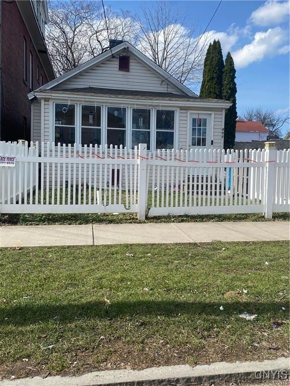 view of front of property featuring a fenced front yard and a sunroom