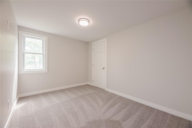 empty room with light colored carpet and baseboards
