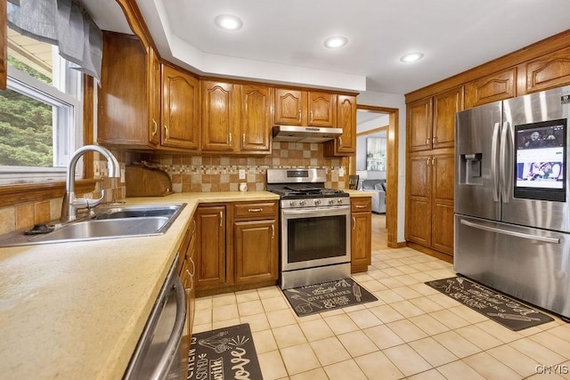 108 Pineledge Rd, Camillus, NY 13031 - kitchen featuring appliances with stainless steel finishes, under cabinet range hood, a sink, brown cabinetry, and recessed lighting