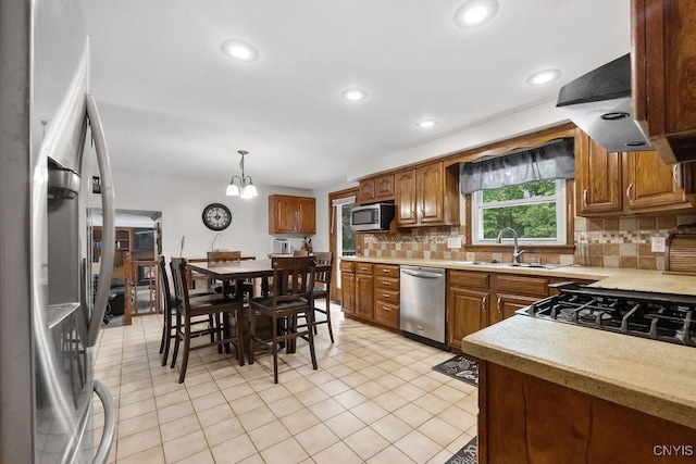 108 Pineledge Rd, Camillus, NY 13031 - kitchen with stainless steel appliances, a sink, light countertops, decorative backsplash, and brown cabinets