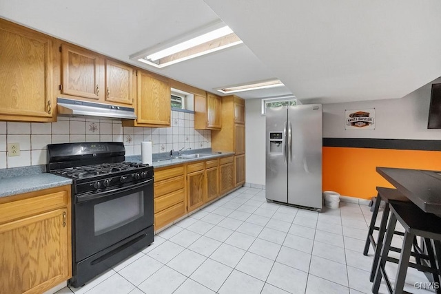 108 Pineledge Rd, Camillus, NY 13031 - kitchen with stainless steel refrigerator with ice dispenser, black gas range, under cabinet range hood, a sink, and backsplash