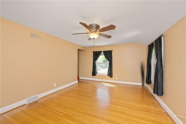 empty room featuring light wood-style floors, a ceiling fan, and baseboards