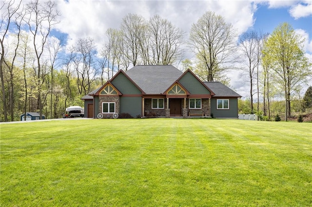 craftsman house featuring stone siding, a front yard, and a garage