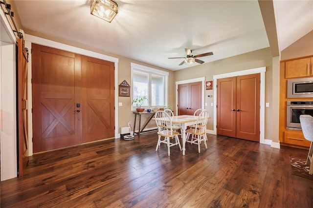 dining area with dark wood-style flooring, a ceiling fan, and baseboards