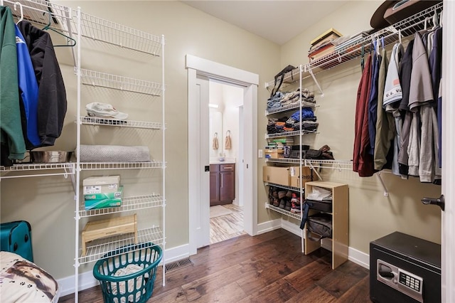 walk in closet with wood finished floors