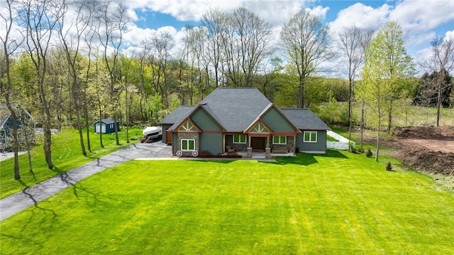 view of front of property featuring a porch, a front lawn, and asphalt driveway