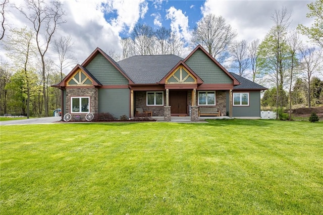 craftsman house with stone siding, covered porch, and a front lawn