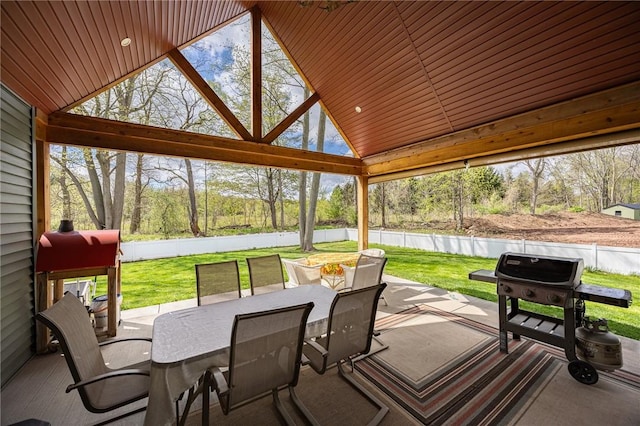 sunroom / solarium featuring outdoor dining space and vaulted ceiling