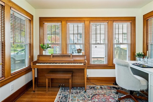 sitting room featuring baseboards, wood finished floors, and a desk