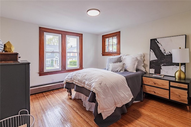 bedroom featuring baseboard heating and wood finished floors