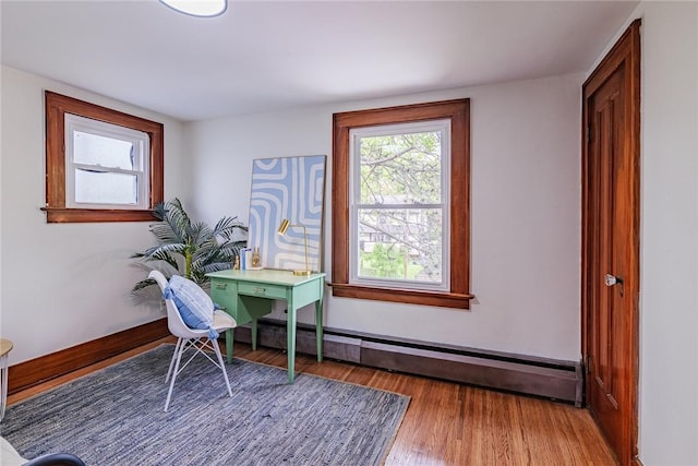 office space with baseboard heating and wood finished floors