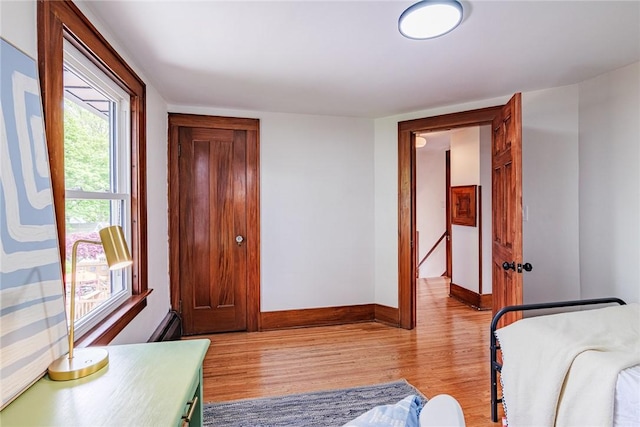 bedroom with light wood-type flooring and baseboards