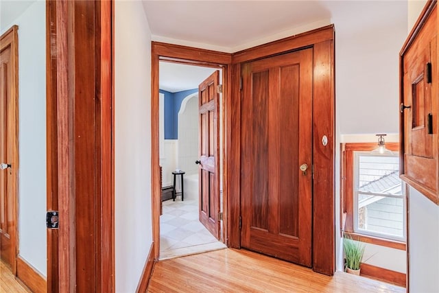 hallway featuring light wood-style floors and baseboards