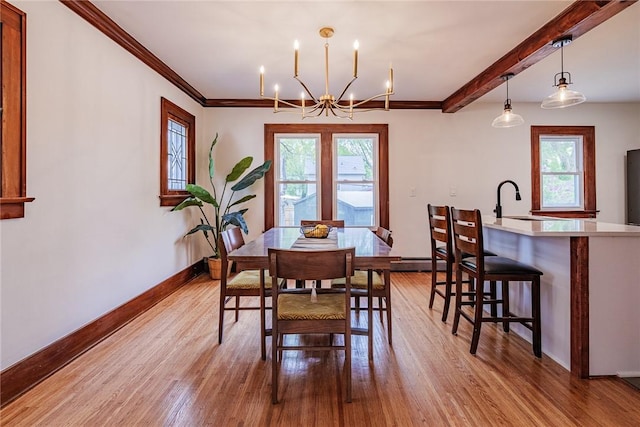 dining room with plenty of natural light, light wood-style floors, a chandelier, baseboards, and beamed ceiling