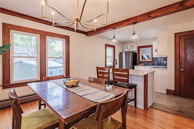 dining room featuring plenty of natural light, light wood-type flooring, beam ceiling, a chandelier, and a baseboard radiator