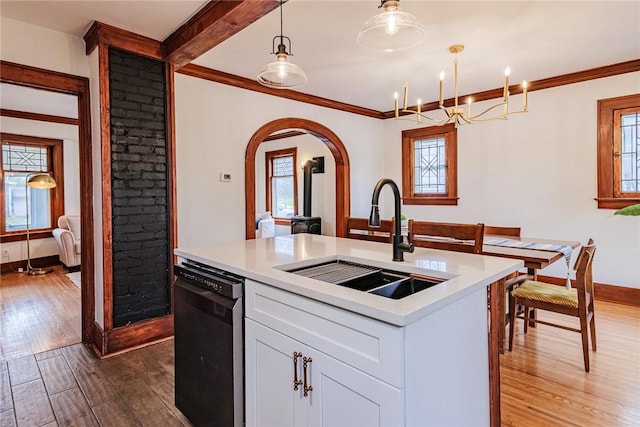 kitchen with a sink, dishwashing machine, dark wood finished floors, baseboards, and a kitchen island with sink